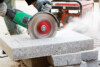 circular saw cutting engineered stone with dust flying